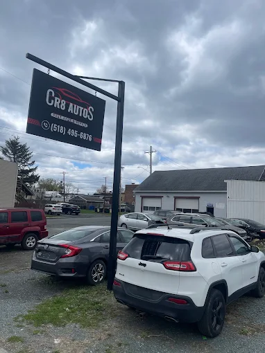 CR8 Autos storefront sign with customer vehicles outside the Watervliet auto body shop